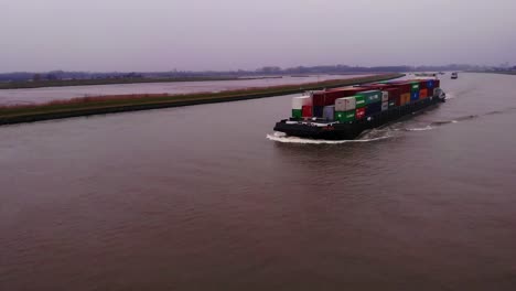 Aerial-View-Of-FPS-Rijn-Ship-Carrying-Containers-On-River-Noord-On-Cloudy-Afternoon