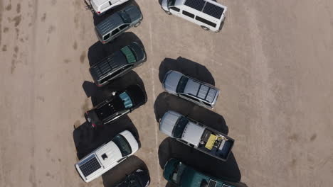 Aerial-top-down-view-of-a-row-of-cars-and-trucks-in-the-desert