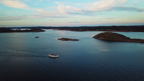 Drone-tracking-small-ferry-up-and-down-during-sunset