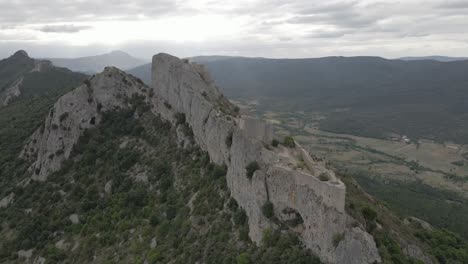 Historic-fortress-atop-steep-vertical-rock-cliff-in-French-Pyrenees
