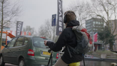 Amsterdamer-Mann,-Der-Tagsüber-Mit-Dem-Fahrrad-Durch-Die-Straßen-Fährt,-4K-Zeitlupe,-Rote-Kamera