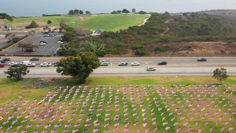 Aerial-Of-Waves-Of-Flags-On-The-Green-Lawn-At-Alumni-Park-At-Pepperdine-University-In-Malibu---drone-pullback
