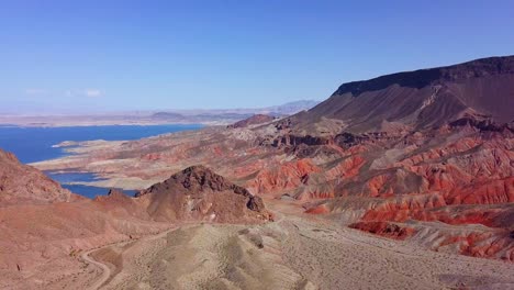 Aerial-view-overlooking-Kingman-wash-desert-and-rocky-mountains-with-Lake-Mead-in-the-background-in-sunny,-USA---pan,-drone-shot