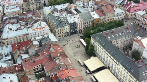 Turistas-Caminando-Por-Las-Calles-De-La-Plaza-Rynok-En-Lviv-Ucrania-Durante-La-Puesta-De-Sol,-Rodeados-Por-El-Ayuntamiento-Y-Edificios-Europeos