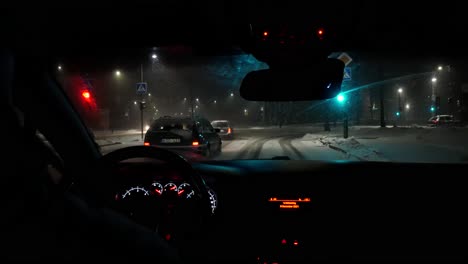 Snow-covered-city-streets-during-heavy-snowfall,-POV-driving-and-making-right-turn