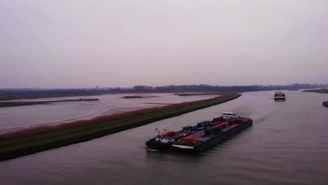 Aerial-View-Of-Maas-Cargo-Ship-Paired-With-Another-Carrying-Cargo-Containers-On-River-Noord-On-Cloudy-Afternoon