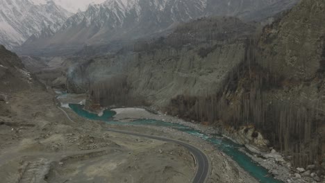 Aerial-Tilt-Down-From-Snow-Capped-Mountains-To-Hunza-Valley-River