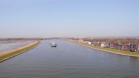 Luftaufnahme-über-Dem-Fluss-Noord-Mit-Blick-Auf-Das-Missouri-Frachtcontainerschiff,-Das-Sich-An-Einem-Sonnigen-Tag-Nähert