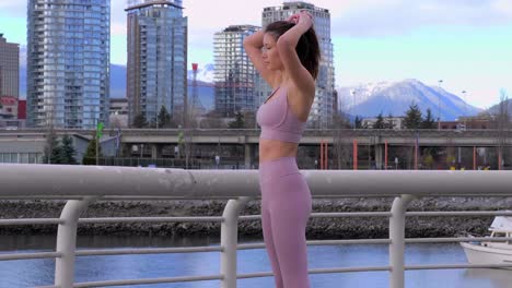 Sporty-Asian-model-poses-and-fixes-hair-with-Vancouver-BC-building-cityscape