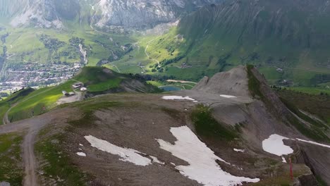 Drohnenaufnahme-Eines-Skigebiets-Im-Sommer-Mit-Bergen-Im-Hintergrund-Und-Schneeflecken