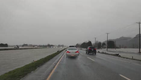 Dashcam-footage-of-vehicles-cautiously-traveling-on-the-wet-roads-of-Highway-1,-heavy-rains-have-flooded-and-submerged-the-low-lying-areas-of-the-Fraser-valley-in-Abbotsford,-British-Columbia,-Canada
