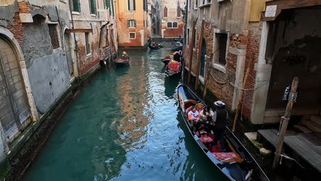 Young-girls-prepare-to-get-off-from-gondola-helped-by-gondolier,-Venice-in-Italy