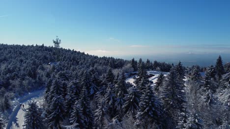 Parking-near-Jested-in-Liberec,-aerial-drone-view-of-trees-and-antenna-transmitter-in-winter