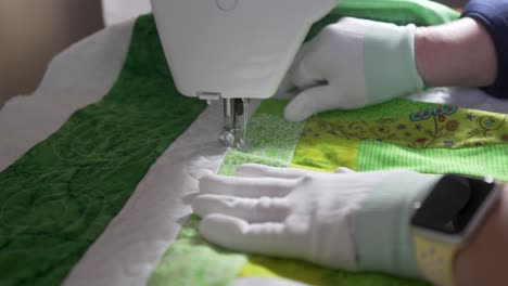 Stitching-in-an-intricate-pattern-on-a-homemade-quilt-using-a-sewing-machine---slow-motion