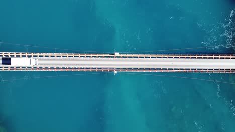 Aerial-top-down-view-of-truck-driving-crossing-over-bridge