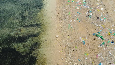 Luftaufnahme-Von-Oben-Mit-Transparentem-Meerwasser-Und-Verschmutztem-Strandsand