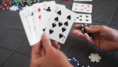 Nahaufnahme-Einer-Person,-Die-Zu-Hause-Poker-Spielt-Und-Chips-In-Der-Hand-Hat