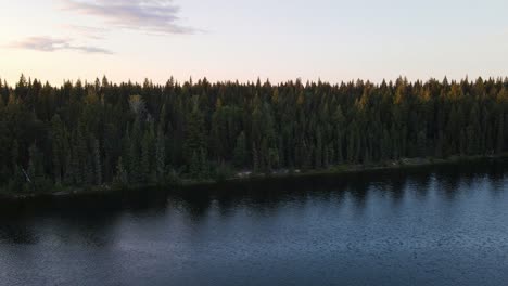 Beautiful-Cobb-Lake-surrounded-by-dense-and-lush-forest-at-sunset-in-British-Columbia,-Canada