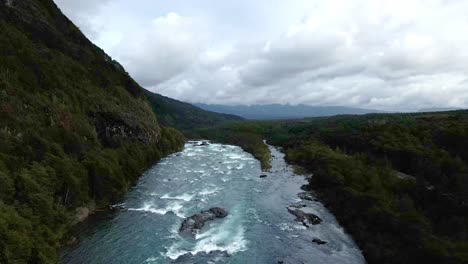 Dolly-Out-Luftaufnahme-Des-Petrohue-Flusses-Mit-Bewölkten-Bergen-Im-Hintergrund,-Südchile