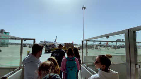 People-wait-to-walk-the-airport-apron-to-the-cruise-plane,-Porto-Airport