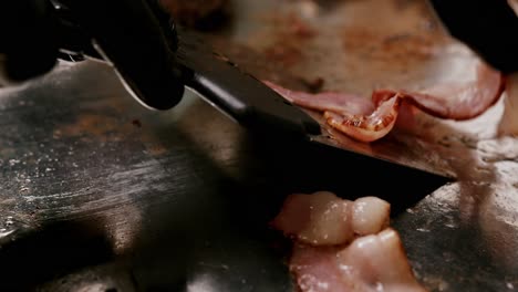 -Frying-delicious-bacon-strips-in-slow-motion-on-a-metal-plate