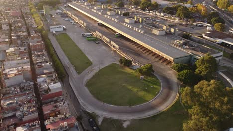 Aerial-flyover-showing-buses-at-Retiro-Train-Station-beside-housing-district-in-Buenos-Aires-City-at-sunset
