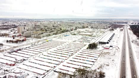 Kalnieciai-district-and-many-garage-boxes-during-heavy-snowfall-in-winter-season,-aerial-view