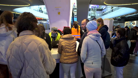 2022-Russian-invasion-of-Ukraine---Central-Railway-Station-in-Warsaw-during-the-refugee-crisis---people-waiting-in-line-to-the-information-point
