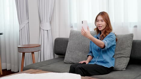 Portrait-of-Asian-young-woman-video-call-with-smartphone-at-home