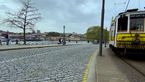 Panoramablick-Auf-Die-Straßenbahn,-Das-Backsteinpflaster-Und-Die-Menschen,-Die-In-Der-Stadt-In-Porto,-Portugal,-Spazieren-Gehen