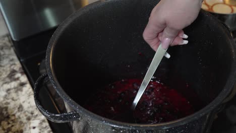 Bringing-the-berries-to-a-boil-to-make-jam---stirring-with-a-spoon