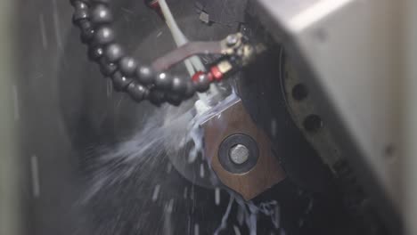 Turning-Mill-Machine-at-the-Modern-Factory,-Automated-CNC-System-Spins-and-Works-With-Water,-Fluids,-Splashes,-Slow-Motion,-Close-Up
