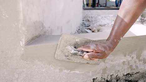 Manual-Worker's-Hand-Plastering-Wall-Using-Hand-Trowel-At-Construction-Site