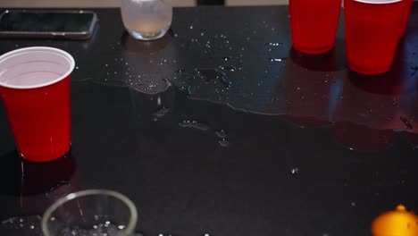 Beer-pong-game-with-a-spilled-drink-and-red-cups