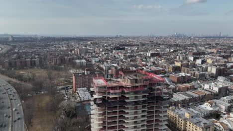 A-high-angle-view-above-a-new-high-rise-construction-site-with-Shore-Parkway-and-the-Verrazano-bridge-in-view