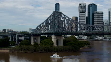 Eines-Der-Wenigen-Boote,-Die-Nach-Den-Überschwemmungen-Im-Februar-2022-Den-Sehr-Braunen-Brisbane-River-Hinauffahren-Durften,-Ist-Beim-Unterqueren-Der-Berühmten-Story-Bridge-Zu-Sehen