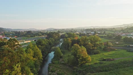 Fluss-Mit-Vegetation,-Der-Parallel-Zur-Autobahn-In-Nordspanien-Fließt,-Mit-Einem-Idyllischen-Sonnenuntergangslicht