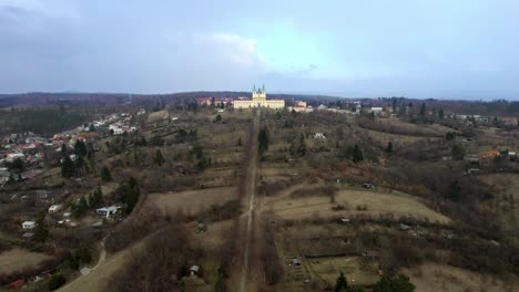 Aerial-Drone-Moves-Over-Hills-Towards-Basilica-of-Minore,-Visitation-of-the-Virgin-Mary-In-Czech-Republic-On-Sunny-Day