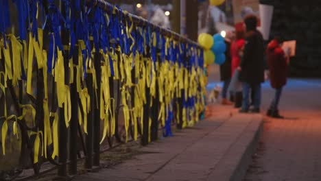Farbbänder-Der-Ukrainischen-Flagge-Auf-Einer-Brücke-Mit-Menschen,-Die-Gegen-Gewalt-In-Der-Ukraine-Protestieren