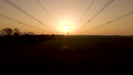 Luftrückzug-Entlang-Stromleitungen,-Silhouette-Eines-Strommastes-Bei-Sonnenuntergang