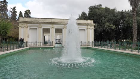 Water-fountain-in-Villa-Comunale-park-in-Lecce,-Italy-with-tourists-taking-pictures