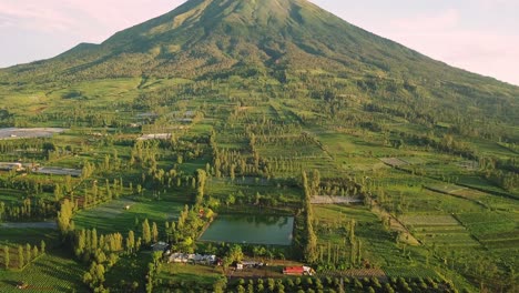 Aerial-view-of-green-Mount-Sindoro-and-lake-during-sunny-day-in-the-evening---Save-water-for-dry-season-in-summer