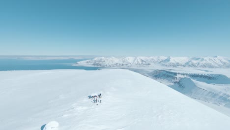 Team-of-hikers-reaching-snowy-mountain-top-in-majestic-landscape-of-Svalbard