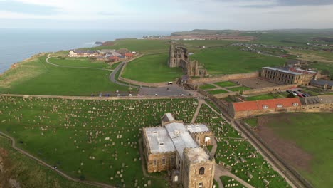 Historic-Saint-Mary's-Church-With-Whitby-Abbey-Ruins-In-The-Distance-In-North-Yorkshire,-England