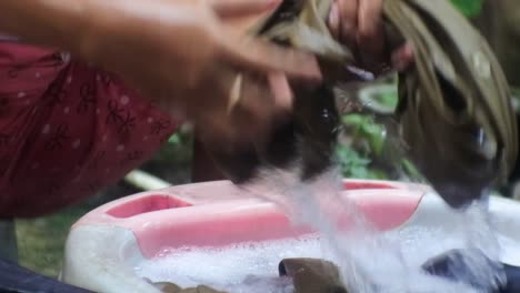 Mujer-Indonesia-Lavando-Ropa-Al-Lado-Del-Baño