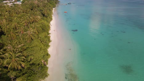 Panorama-Der-Maledivischen-Insel-Mit-Einer-Küste,-An-Der-Sich-Ein-Pier-Und-Ein-Liegeplatz-Im-Türkisfarbenen-Wasser-Befinden
