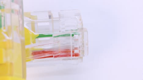 Nahaufnahme-Eines-Ethernet-Kabels-Aus-Gelbem-Kunststoff,-Das-Auf-Einer-Weißen-Oberfläche-Rotiert,-Makroaufnahme-Von-Oben-In-4K
