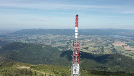 Aerial-orbit-shot-of-gsm-tower-transmitter-on-Skrzyczne-Hill-with-Silesian-Beskid-and-Żywieckie-lake-in-the-background