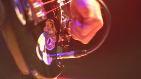 Bass-player-connecting-instrument-and-moving-knobs-in-stage