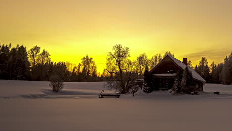 Scenic-Winter-Wonderland-Sunset-At-Snowy-Countryside-With-Small-Wood-House